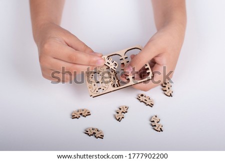 wooden designer in children's hands on a white background