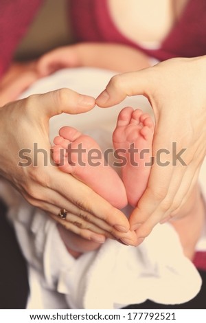Mother holding feet of baby 