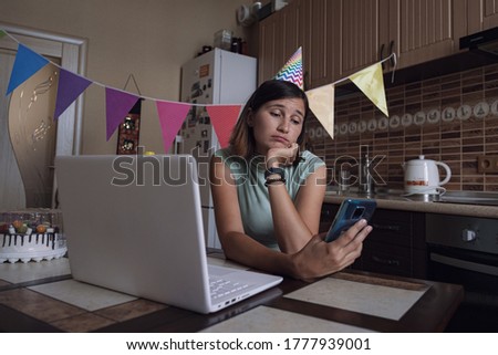 Girl celebrating birthday online in quarantine time. Woman celebrating her birthday through video call virtual party with friends. Authentic decorated home workplace.