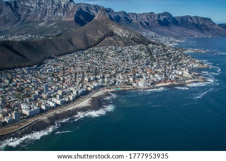 Selective focus aerial view of Cape Town's Green Point and Sea Point with Signal Hill, Table Mountain and The 12 Apostles Mountains visible.