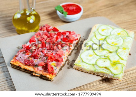 Pizza with tomato, ham, pesto and zucchini