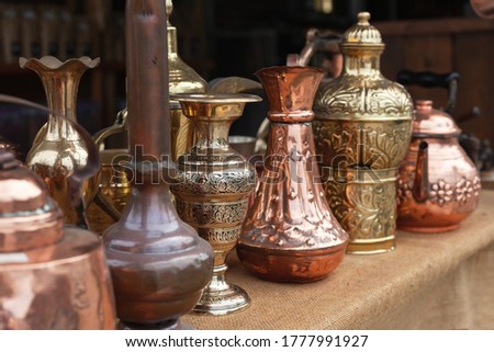 Assortment of stylized Oriental copper dishware standing on a counter of a gift shop in Jordan