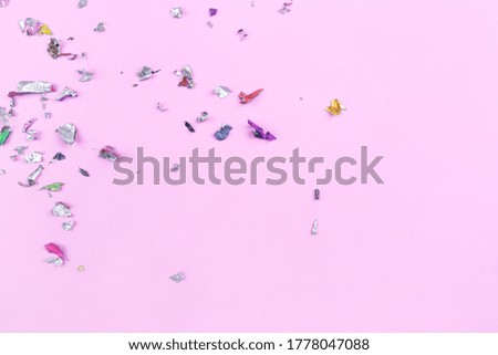 Multicolored confetti on pink background. Flat lay, top view.