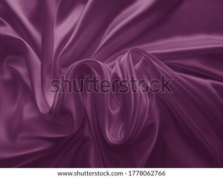 Beautiful elegant wavy dark purple satin silk. Luxury cloth fabric texture, abstract background design. Card or banner.