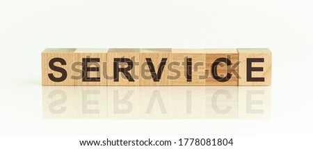 Wooden Blocks with the text: service. The text is written in black letters and is reflected in the mirror surface of the table. New business relaunch startup concept.