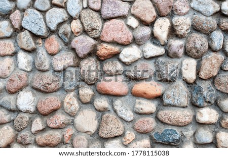 Paved walls made of natural stone, round and oval cobblestones.
