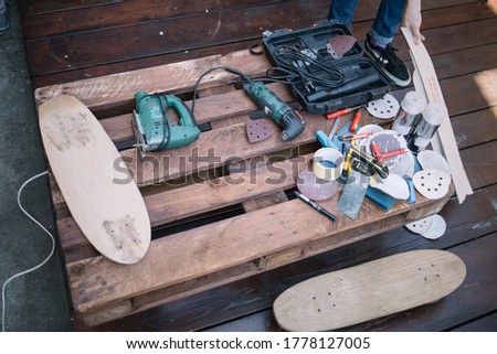 Top view of wooden pallet with handyman tools and skateboards. Tools for making skateboard on pallet in workshop.