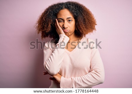 Young african american woman with afro hair wearing casual sweater over pink background thinking looking tired and bored with depression problems with crossed arms.