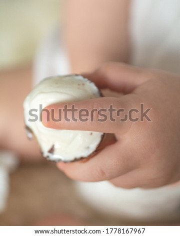 A baby girl hand holding sweet ice cream cone.