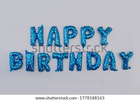 Happy Birthday word blue Balloon 3d font photography isolated with simple grey background and banner space for text metallic plastic shiny reflection child happy celebration colorful 