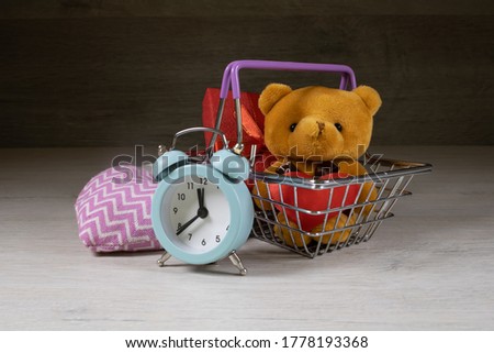Shopping basket with gifts inside on a dark wooden background.