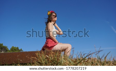 young woman sitting against blue background
