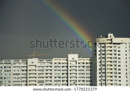 rainbow over building in cloudy day