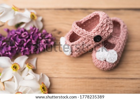 Small, hand-made shoes for a newborn baby. Needlework. Composition on oak boards. View from above. Flat Lying picture.