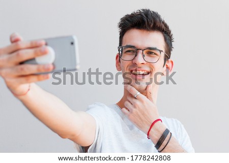 Handsome man takes a selfie with smartphone