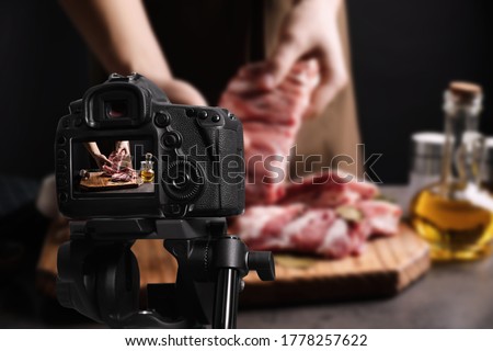 Food photography. Shooting of man holding raw ribs, focus on camera