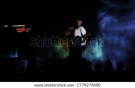 asian man sing song with on flash light concert at night