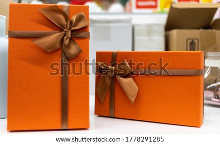 gift box of a pleasant orange hue, tied with a ribbon with a bow. High quality photo