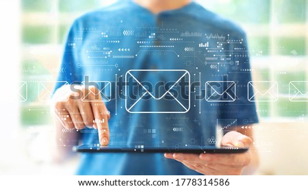 Email concept with young man using a tablet computer