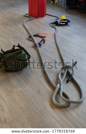 Gym equipment for boot camp and work out with kettle bell, rope, sandbag in gym hall on the floor. Vertical shot.