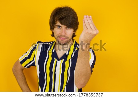 What the hell are you talking about. Shot of frustrated young European man gesturing with raised hand doing Italian gesture, frowning, being displeased and confused with dumb question.