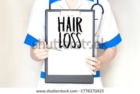 Doctor holding a paper plate with text hair loss, medical concept