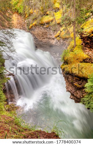 Long exposure of waterfall motion at Johnston Canyon Cavern Falls in Banff National Park, Canada.  The canyon walls are carved steeply into the limestone bedrock by thousands of years of water erosion
