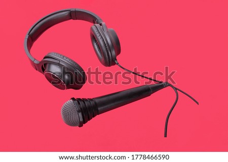 black headphones and microphones on a red background