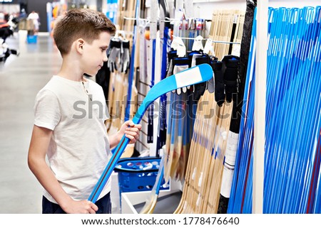 Boy with hockey stick in a sporting goods store