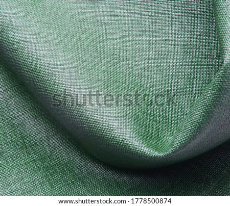  Background of green fabric material. Folds, narrow focus, abstraction, space for text                              