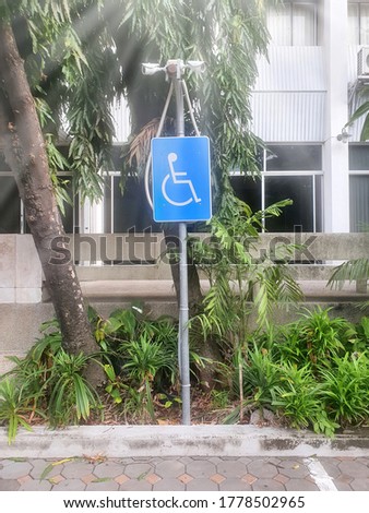 International handicapped symbol painted in bright blue on parking space. Disabled handicap parking space reserved for handicapped.
