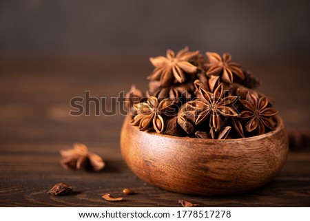 star anise in a wooden bowl on the table, close up Royalty-Free Stock Photo #1778517278