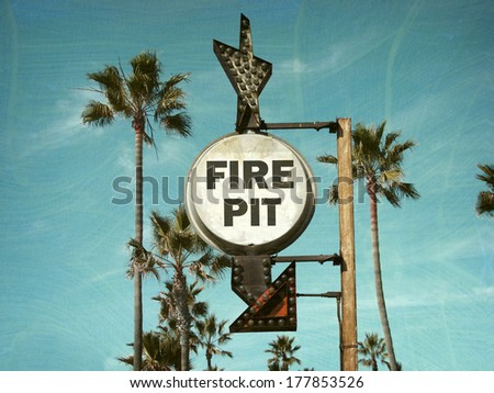  aged and worn vintage photo of fire pit sign with palm trees                             