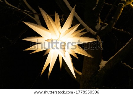 Street New Year and Christmas decorations. Decorative, winter festive lantern in the shape of a star on a Christmas tree for the celebration of Christmas is covered with snow. Copy space