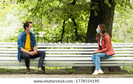Couple have date during the coronavirus lockdown crisis. Man and woman in the park. Social distancing and virus protection. Royalty-Free Stock Photo #1778554190