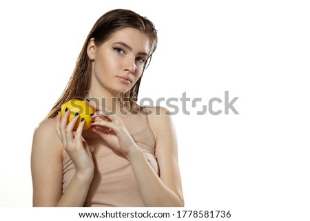 Portrait of beautiful young woman with fresh lemon near face over white background. Concept of cosmetics, makeup, natural and eco treatment, skin care. Shiny and healthy skin, fashion, healthcare.