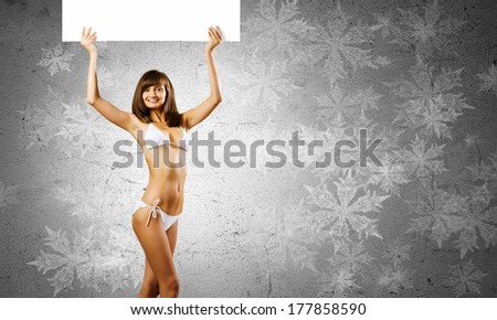 Young pretty girl in bikini holding blank banner