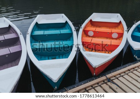 Colorful boats tied to the dock by the lake at the end of the day.