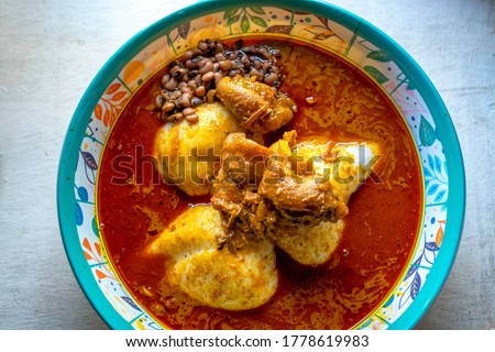 picture of local Ghanaian dish rice balls with palm nut soup,beans and beef meat in a bowl.focus on meat 