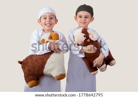 Little Muslim kids playing with sheep toys - celebrating Eid Al Adha - Happy Sacrifice Feast Royalty-Free Stock Photo #1778642795
