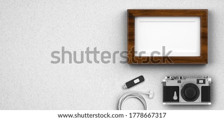 photo camera and empty picture frame on white background