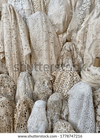 Group of white fabrics, with different textures, ready to be sold in a market