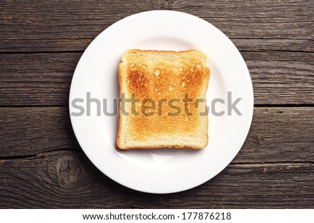 Toast bread in a white plate on vintage wooden background. Top view Royalty-Free Stock Photo #177876218