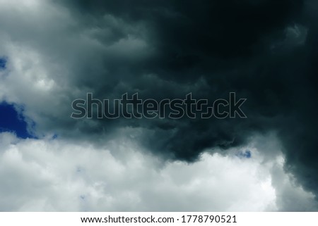 Dark clouds from a clear sky foreshadow a thunderstorm and a hurricane.