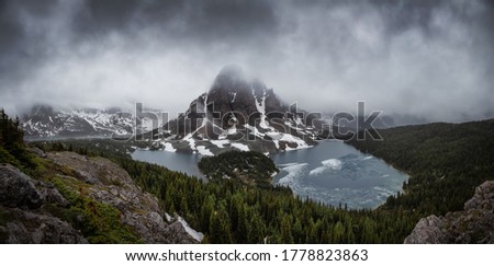 Beautiful panoramic View of the Iconic Canadian Rocky Mountain Landscape during a Dark and Moody Sunset. Taken near Banff, boarder of British Columbia and Alberta, Canada. Nature Background Panorama