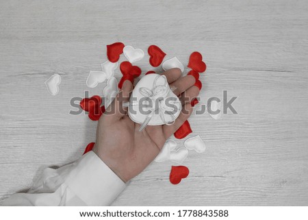 Male hand holding a gift in one hand.