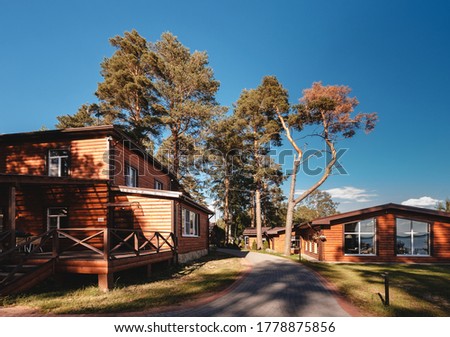 Traditional wooden cottages at sunny day in the countryside. Beautiful wooden house near the river. scandinavian holiday house background