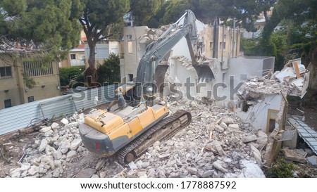  Urban Regeneration. Demolition of a building for new construction. Dismantling of a house. Excavator demolishing barracks for new construction project. Urban Renewal‎. Royalty-Free Stock Photo #1778887592