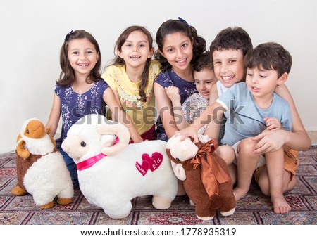 Happy little Muslim kids playing with sheep toys - celebrating Eid Al Adha - Happy Sacrifice Feast Royalty-Free Stock Photo #1778935319