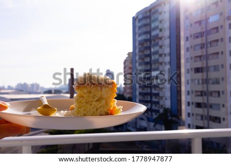 close up of homemade coconut cake with building in the background